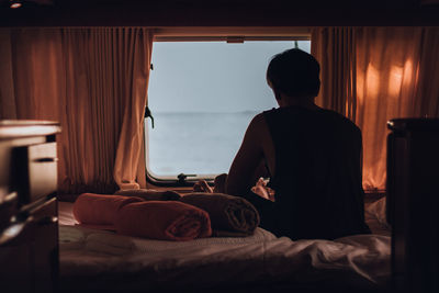 Rear view of people relaxing on bed at home