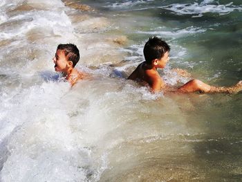 High angle view of boys swimming in river