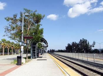 Railroad tracks by trees against sky