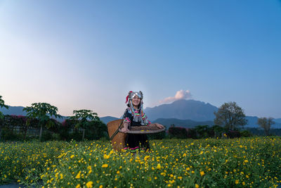 Scenic view of flowering plants on field against sky