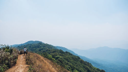 Man looking at mountain against sky