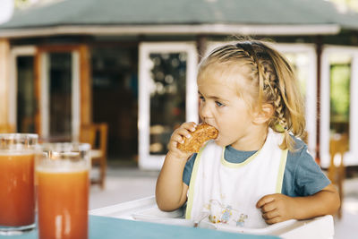 Portrait of cute boy eating food at restaurant