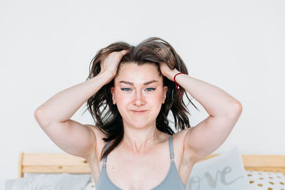 Portrait of a smiling young woman against wall