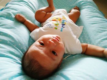 High angle view of baby lying on bed