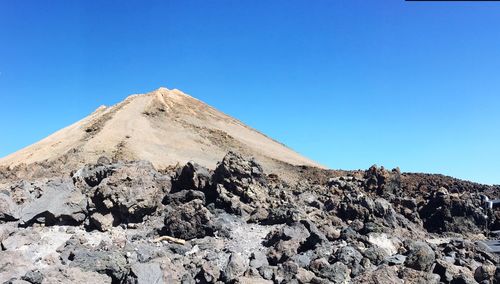 Low angle view of mountain against blue sky