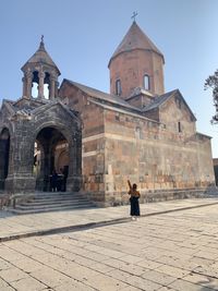 Woman walking in front of historic building