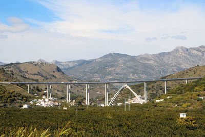 Bridge over mountains against sky