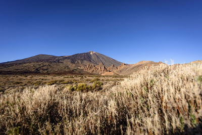 Scenic view of mountains against clear blue sky