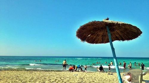 People on beach against blue sky