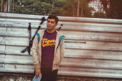 Man standing against corrugated iron