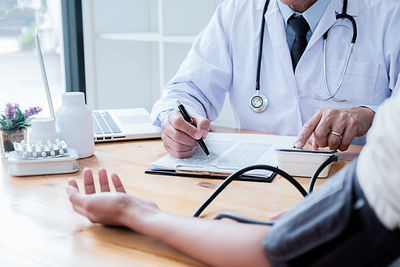 Midsection of man using laptop on table