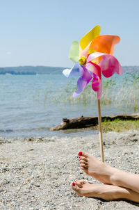 Low section of woman on beach against clear sky