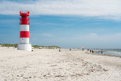 Lighthouse by sea against sky