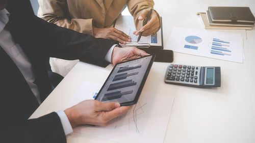 Midsection of businessman using laptop on table