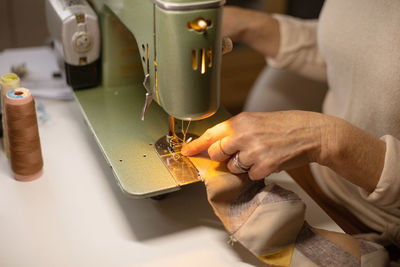 Closeup view of womans hands sewing fabric with a vintage, retro sewing machine. fashion, creation