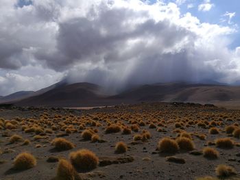 Scenic view of desert against dramatic sky