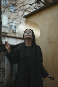 Man looking up while standing against wall