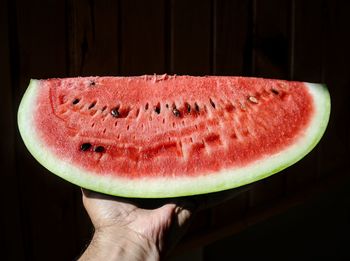 Cropped hand holding watermelon slice