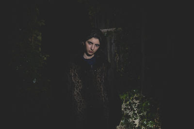 Portrait of young woman standing in abandoned house