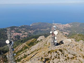 High angle view of communications tower by sea against sky