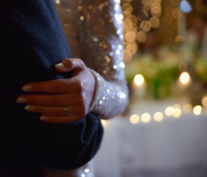 Close-up of hand holding illuminated christmas lights