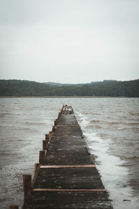 Pier over lake against sky