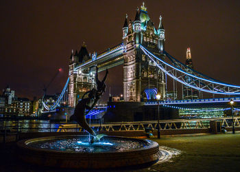 Low angle view of illuminated tower bridge at night