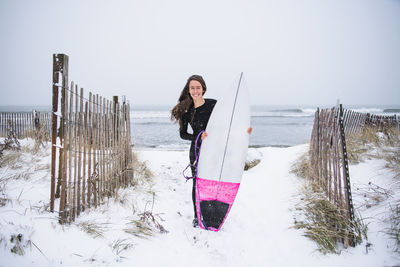 Woman going surfing during winter snow