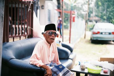 Man wearing sunglasses sitting in city