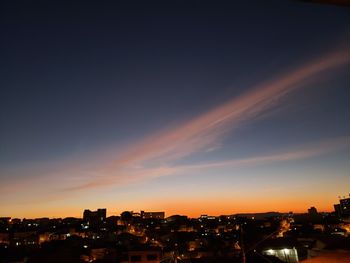 Illuminated buildings against sky during sunset