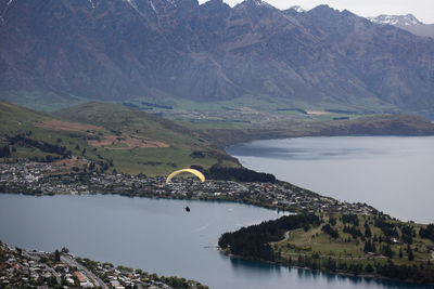 High angle view of person paragliding against lake