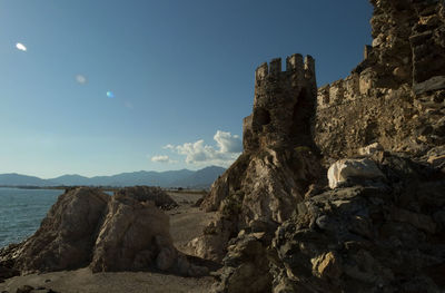 Rock formations by sea against sky