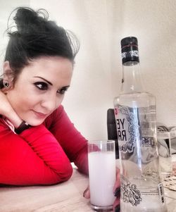 Portrait of woman with drink in glass on table