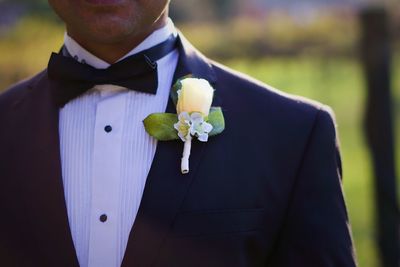 Midsection of man holding flower in garden