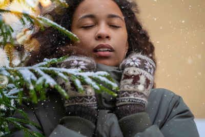 Low angle view of young woman standing against plants