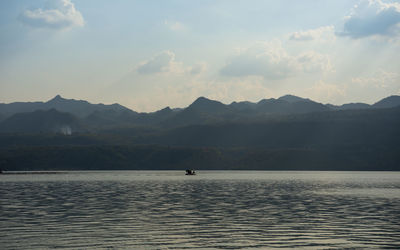 Scenic view of sea and mountains against sky