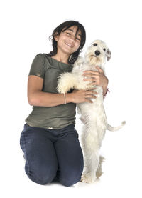 Portrait of a young woman with dog against white background