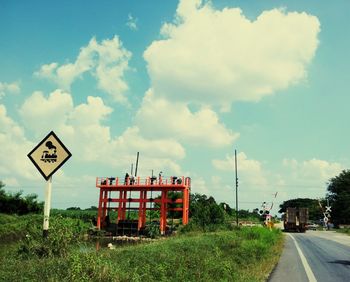 Road sign against cloudy sky