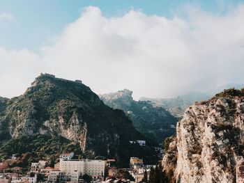 Panoramic view of townscape by mountain against sky