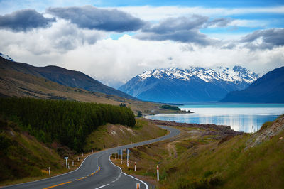 Scenic view of road by mountains against sky