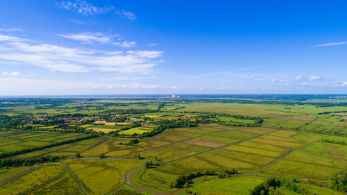 Scenic view of agricultural field against blue sky