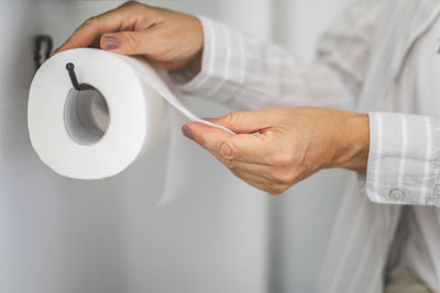 Midsection of man holding toilet paper