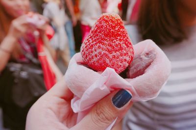 Cropped image of woman holding strawberry dessert