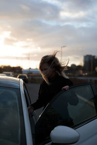 Side view of young woman looking through window