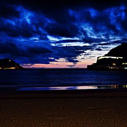 Scenic view of sea against cloudy sky at dusk