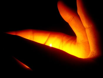Close-up of illuminated light bulb against black background