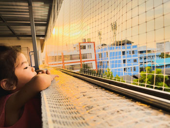 Rear view of boy looking through train at railroad station