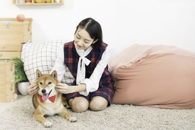 Pet lover concept. the girl is smiling with the shiba inu dog on in the living room. 