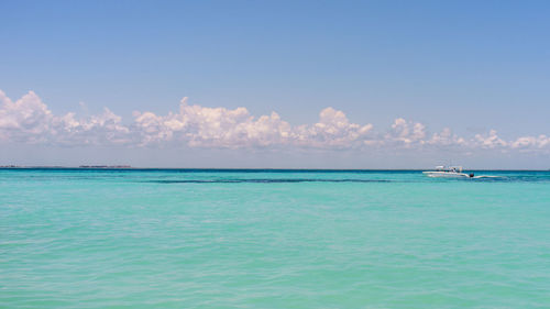 Motorboat sailing in sea against sky