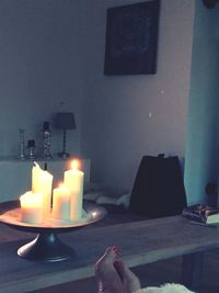 Close-up of illuminated candles on table at home